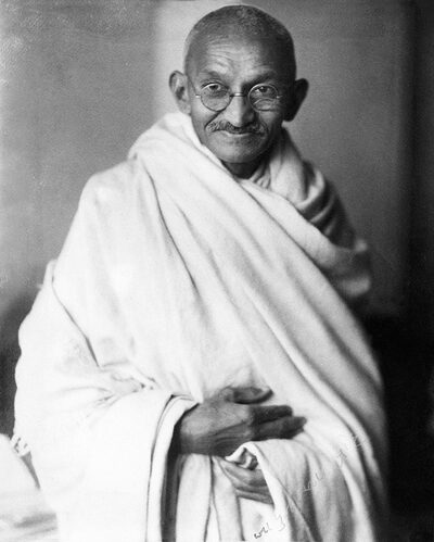 Mahatma Gandhi walking with a staff